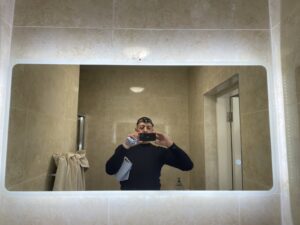 Round LED bathroom mirror professionally installed above a vanity unit